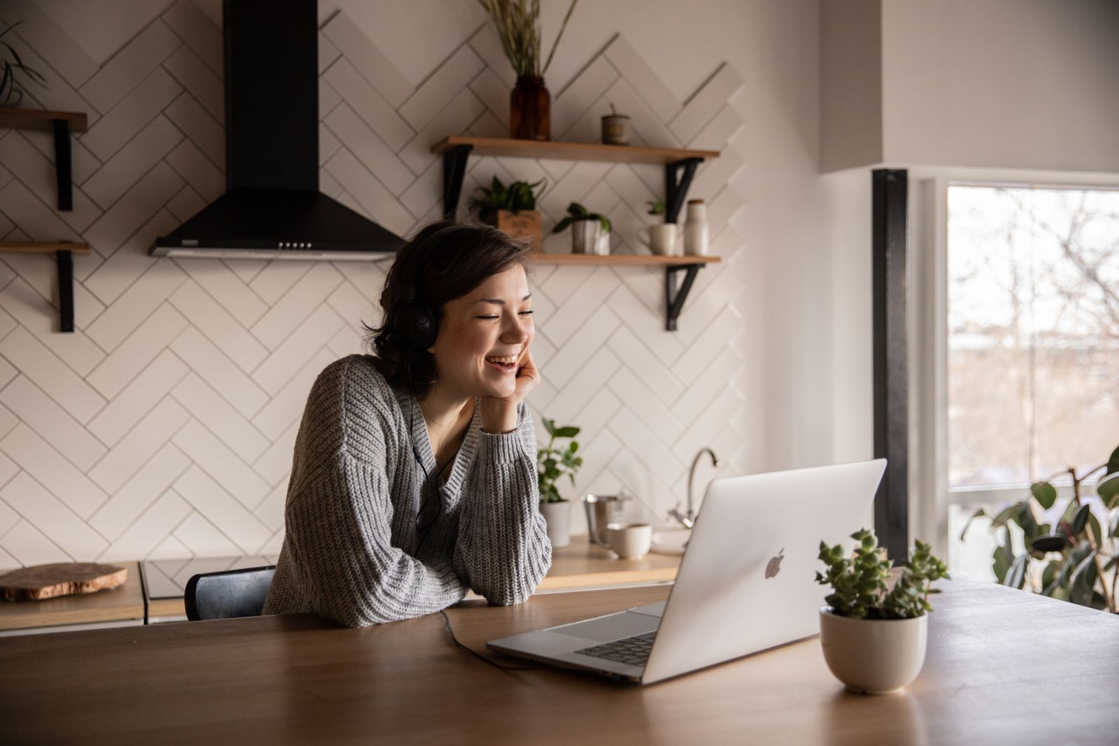 A parent and child on a video call at a kitchen table