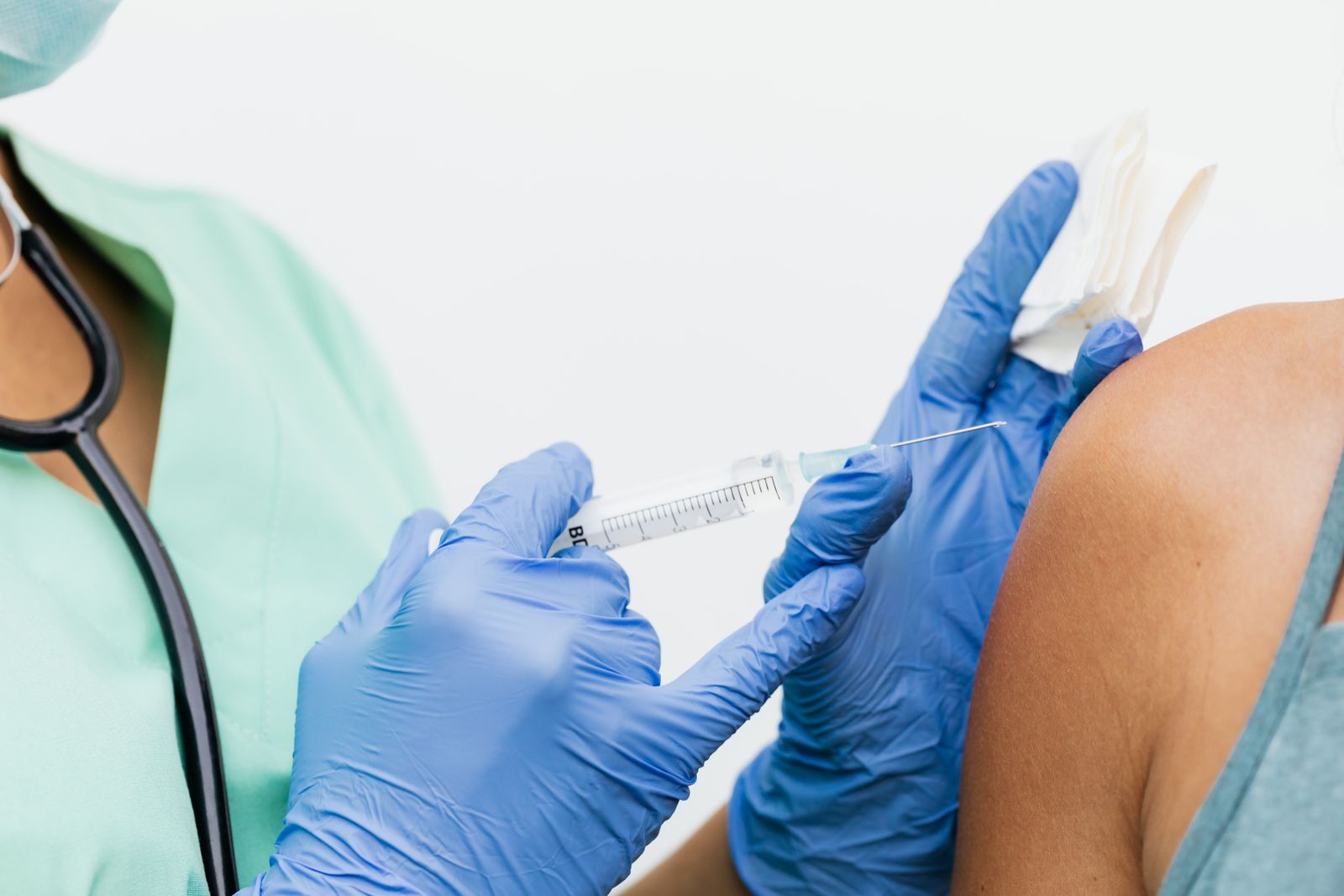 A nurse giving a vaccination into a child's upper arm