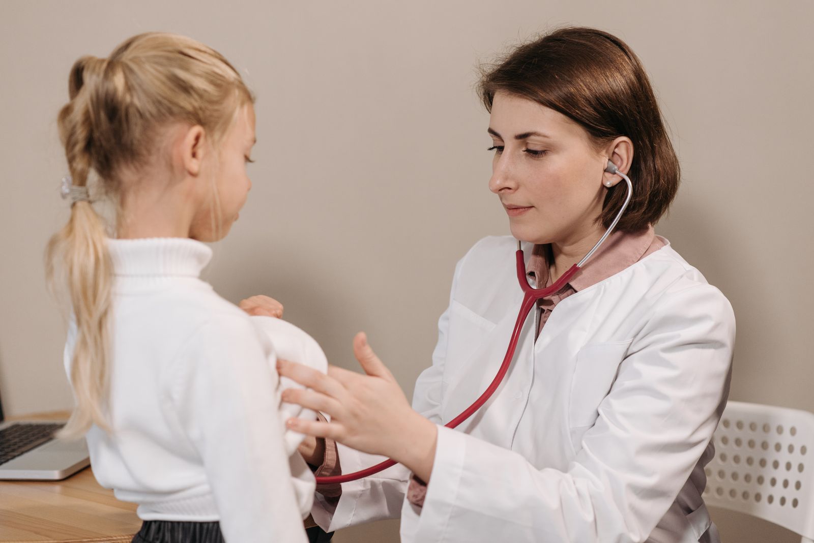 A clinician checking a child with a stethoscope
