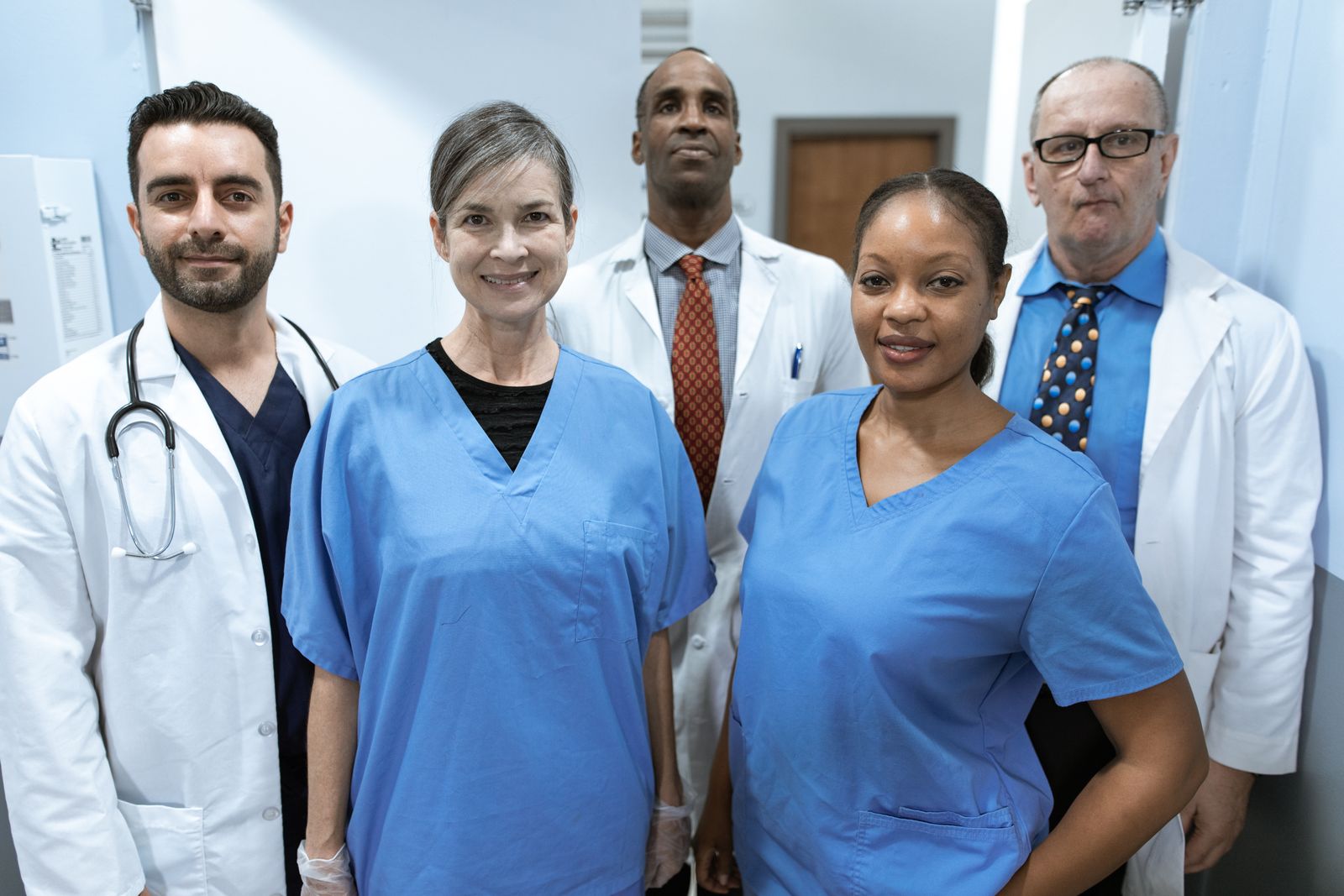 Clinic staff talking together in a bright corridor